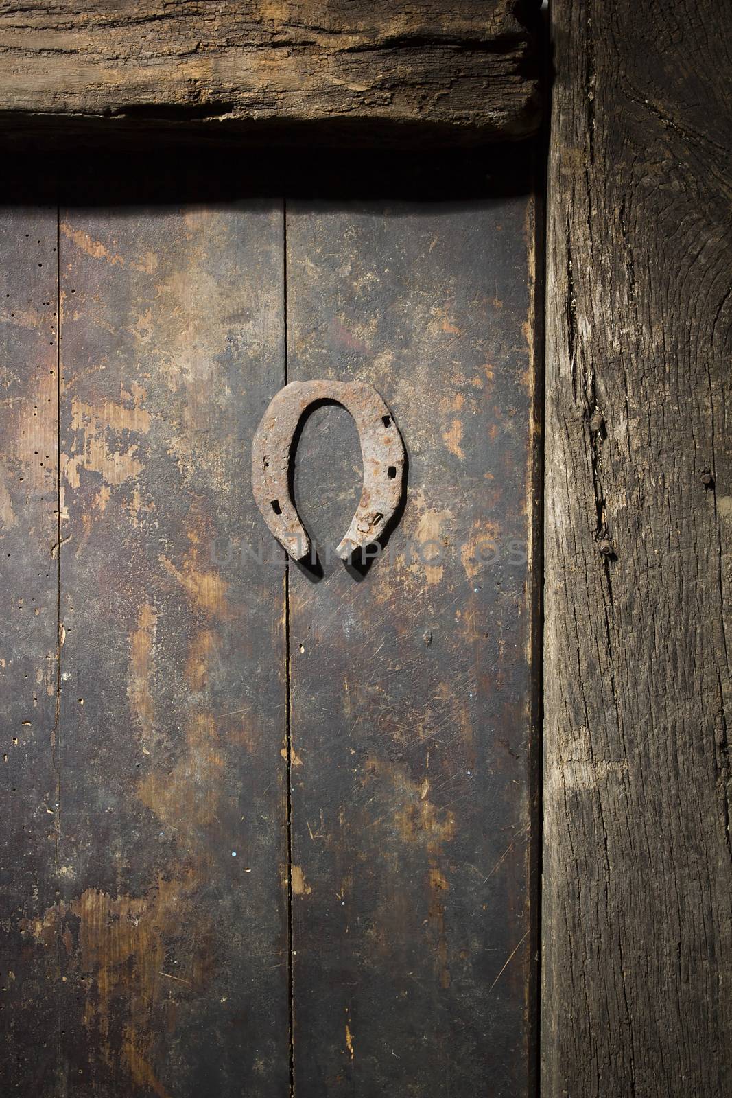 Rusty horseshoe on an ancient wooden door