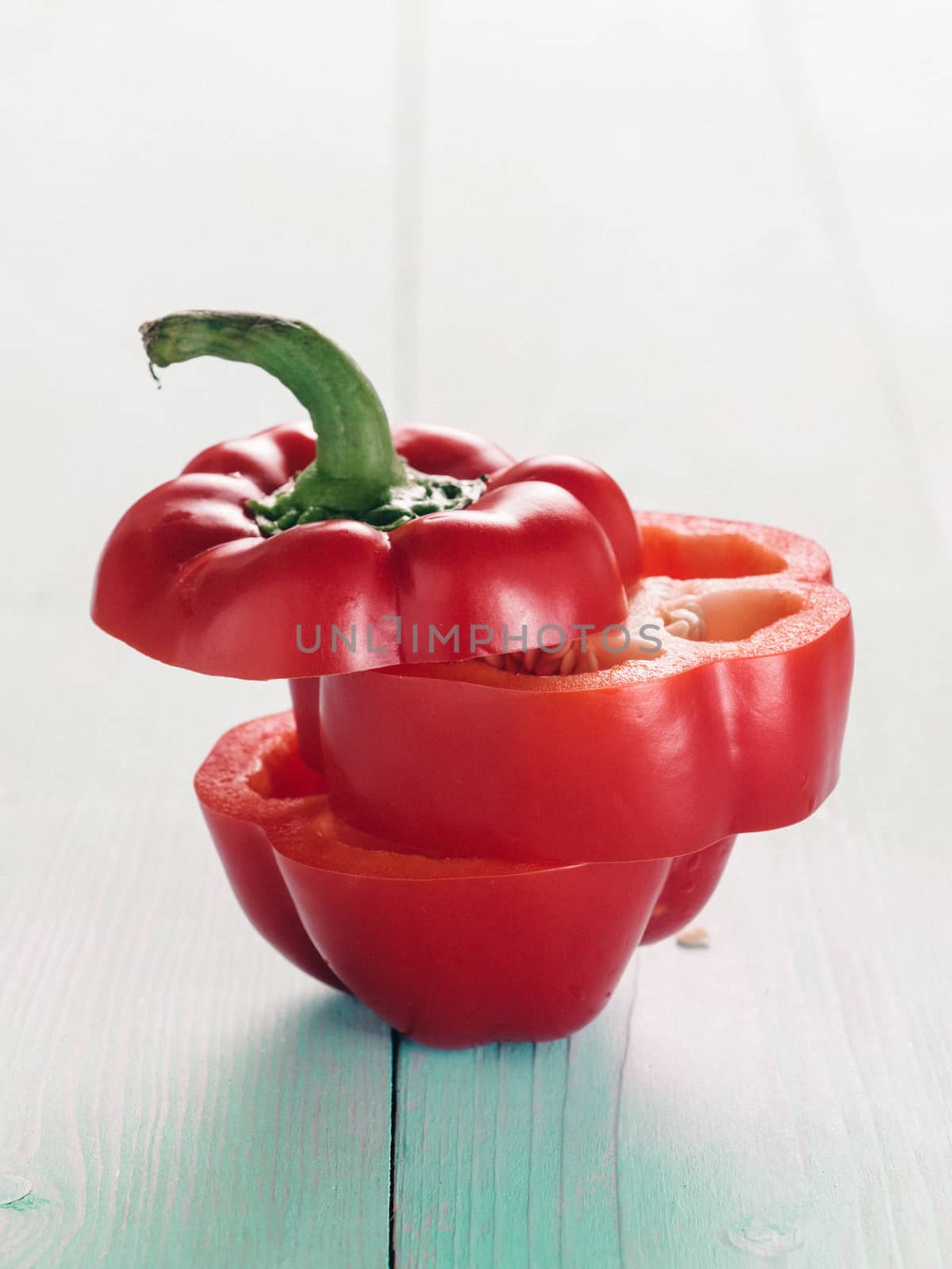 Sweet red peppers sliced on blue wooden background by fascinadora