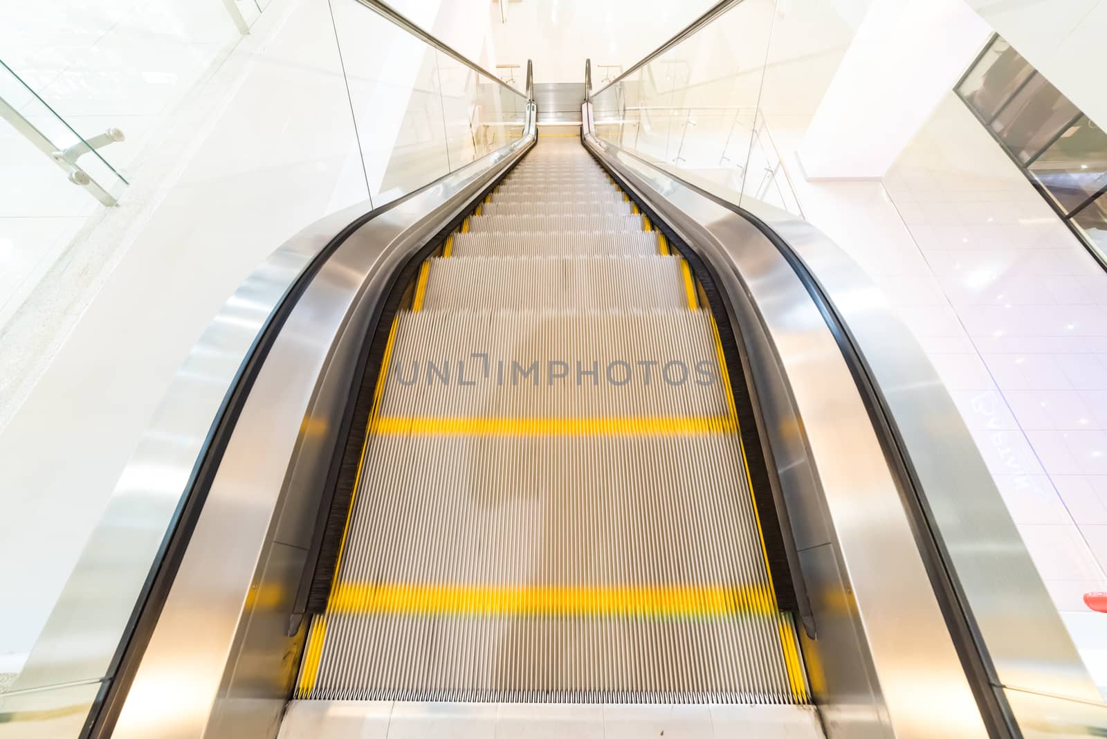 Close up escalator with yellow line in shopping mall. by spukkato
