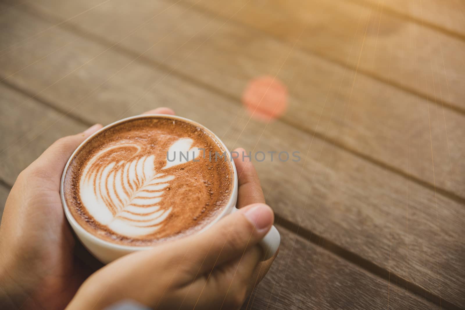 Woman hands holding cup of hot coffee latte cappuccino with hear by spukkato
