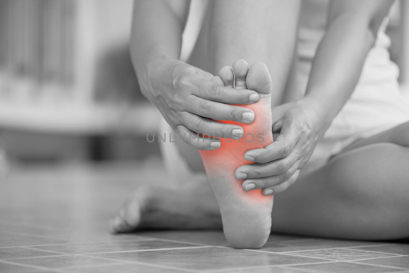 Closeup young woman feeling pain in her foot at home. Healthcare and medical concept.