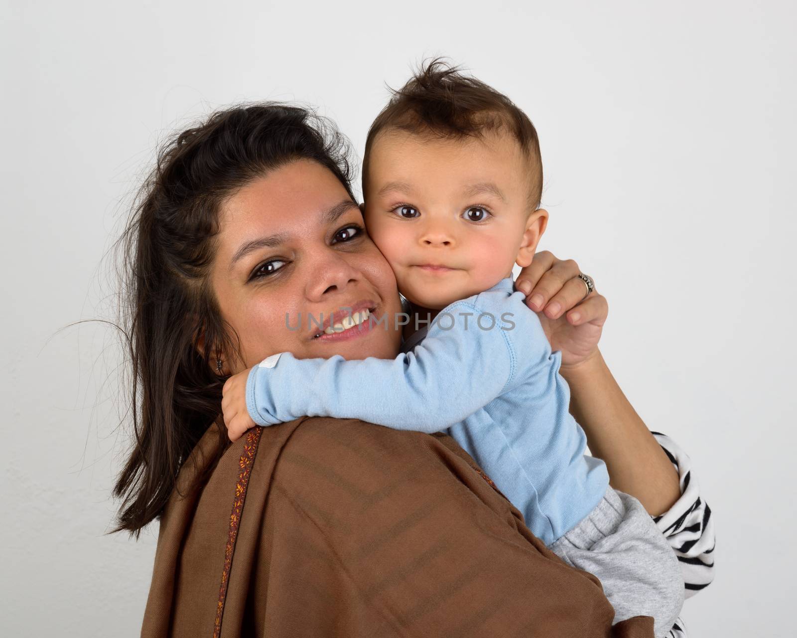 Smiling south asian mother holding her eurasian baby