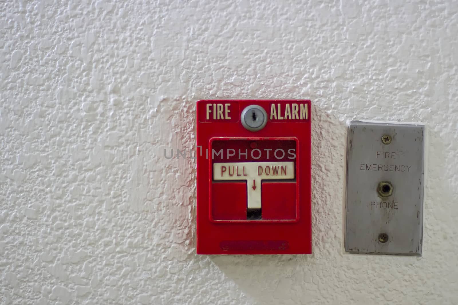 Red antique fire alarm button with white wall by TakerWalker