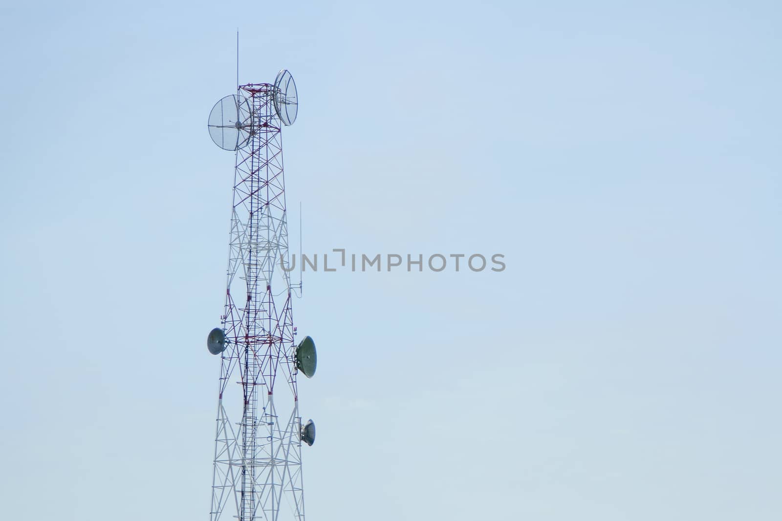 Mobile phone communication tower transmission with blue sky background and antenna