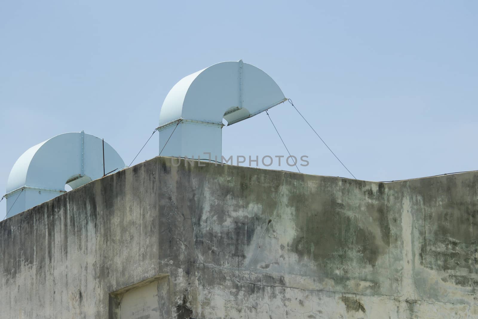 Blue air duct With a bare cement wall With blue sky