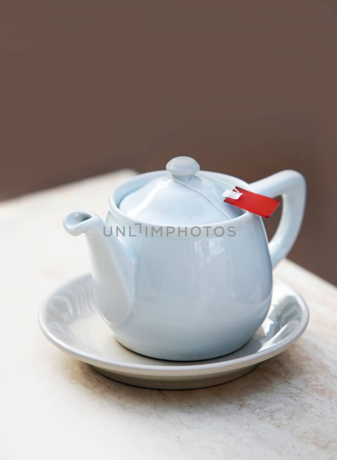 White teapot with tea bag by friday