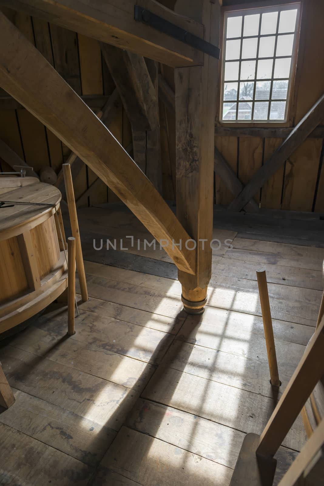 Interior of a historic wooden mill with a detail of an old wooden crusher in the area with beautiful light
