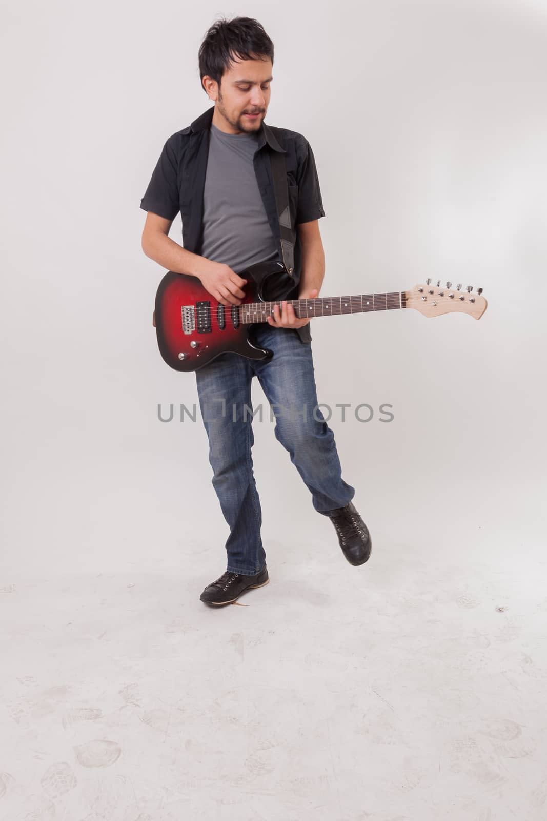 young man jumping with electric guitar by oaltindag