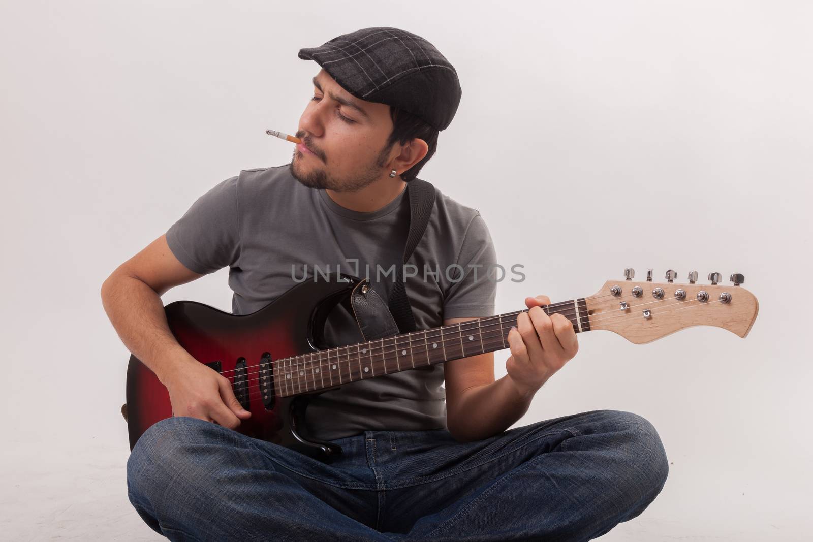 young man jumping with electric guitar on white background