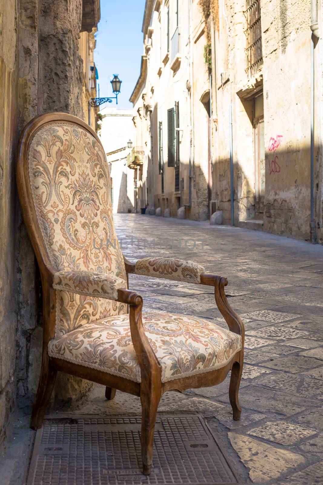 Lecce town, Italy. Vintage chair with old town street in background.