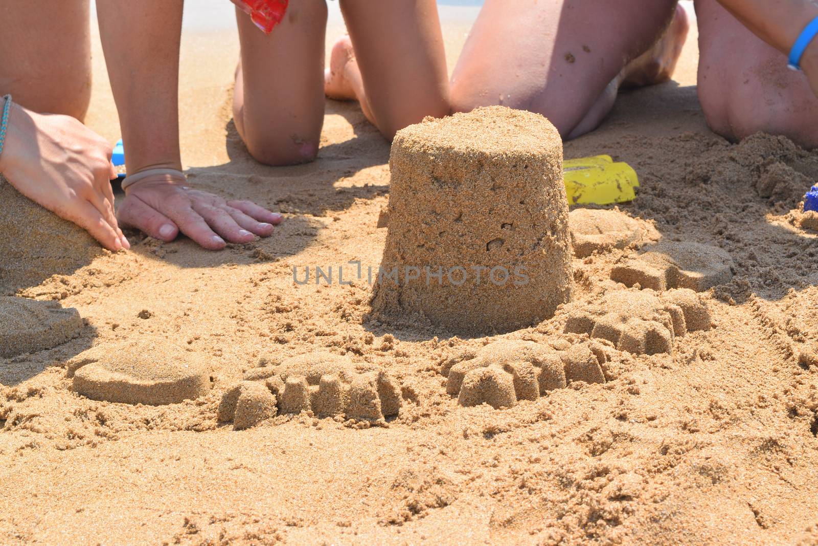 building a sand castle on the beach by solosergio