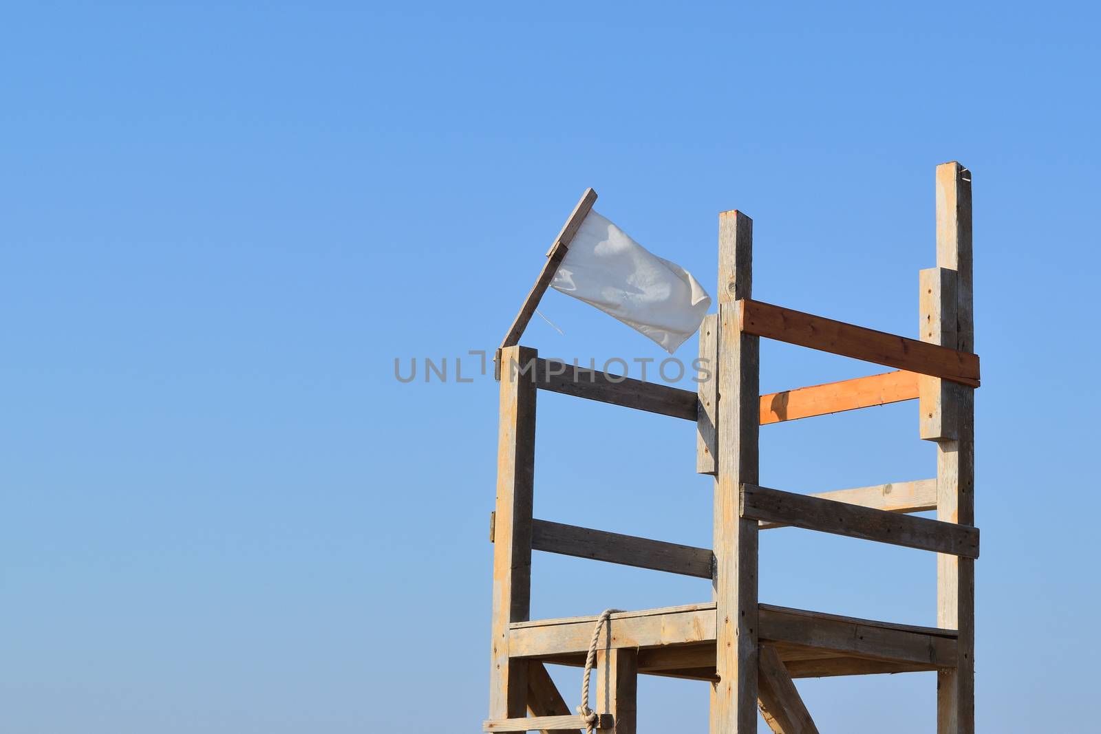 white flag in the wind on a beachguard chair