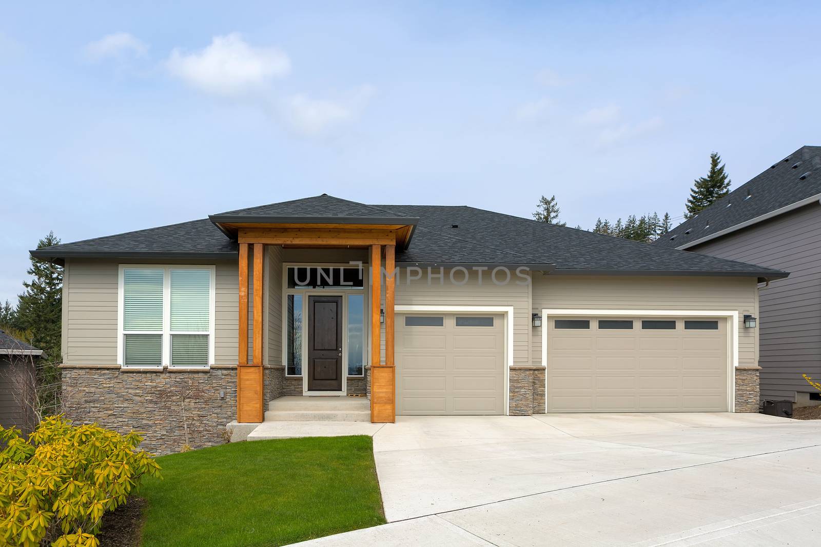 New custom built house in Happy Valley Oregon suburban neighborhood with three car garage and manicured front lawn