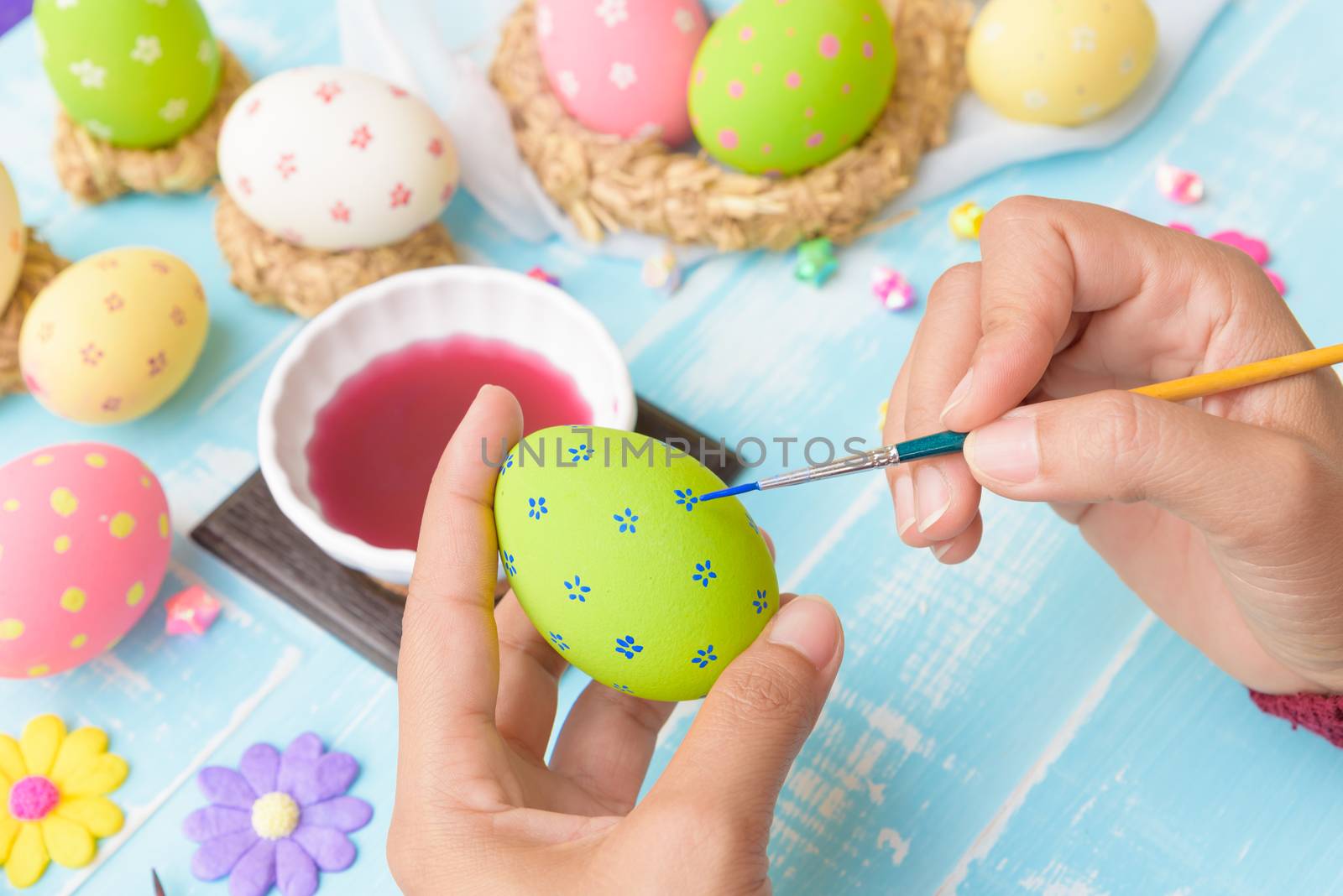 Happy easter! A woman hand painting Easter eggs. Happy family pr by spukkato