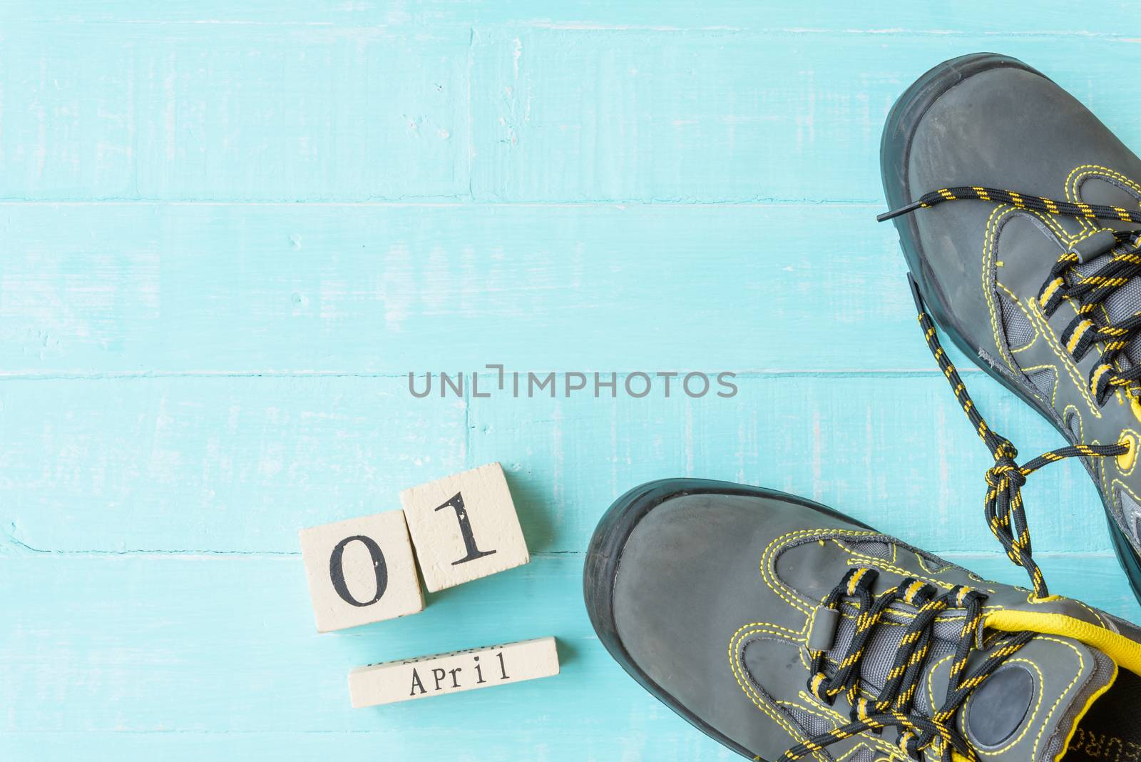 April fool's day concept. shoelaces tied together and Wooden block calendar with empty space for text on bright blue and white wooden background.