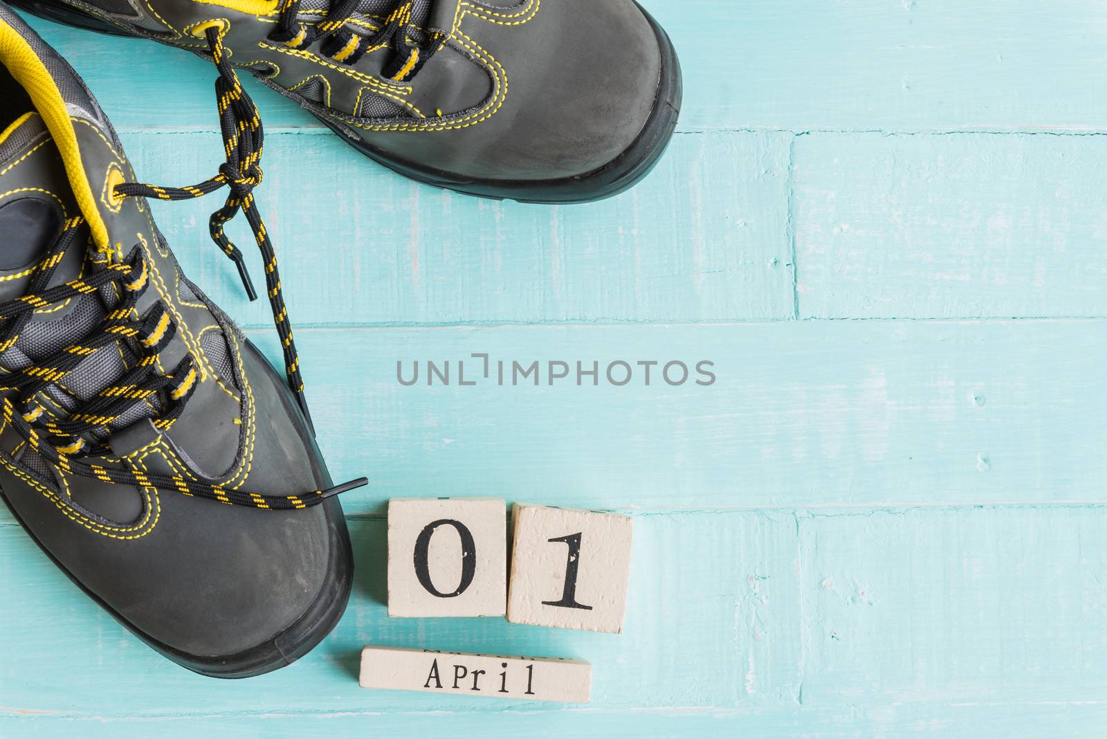 April fool's day concept. shoelaces tied together and Wooden block calendar with empty space for text on bright blue and white wooden background.