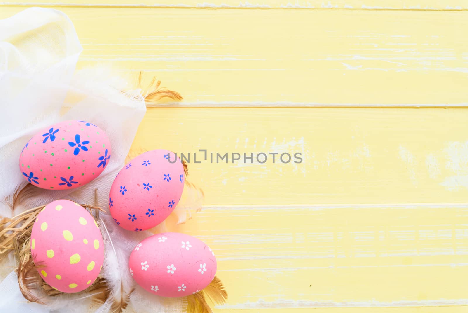 Happy easter! Colorful of Easter eggs in nest with paper star, flower and Feather on pastel color bright blue and white wooden background.