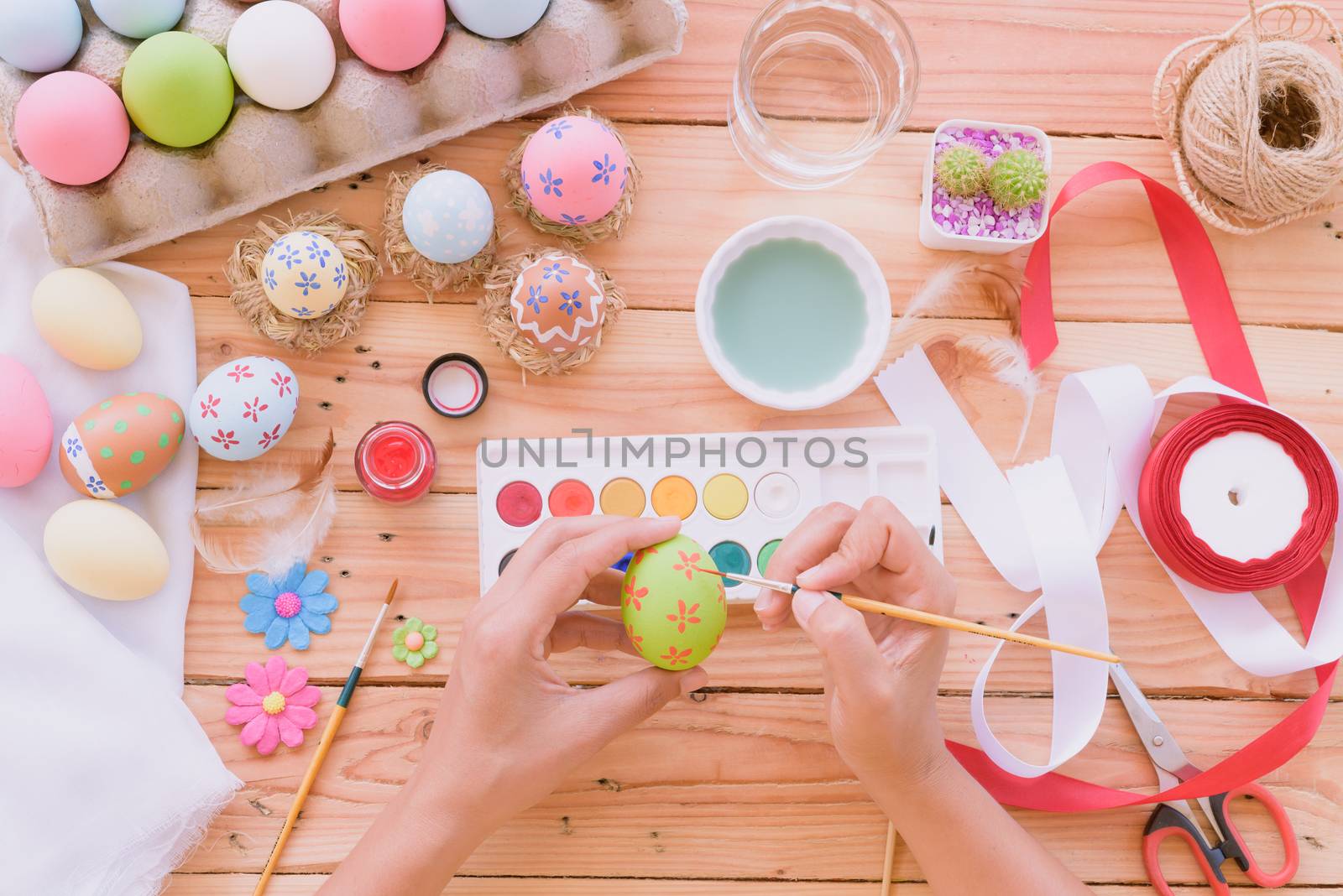 Happy easter! A woman hand painting Easter eggs. Happy family pr by spukkato