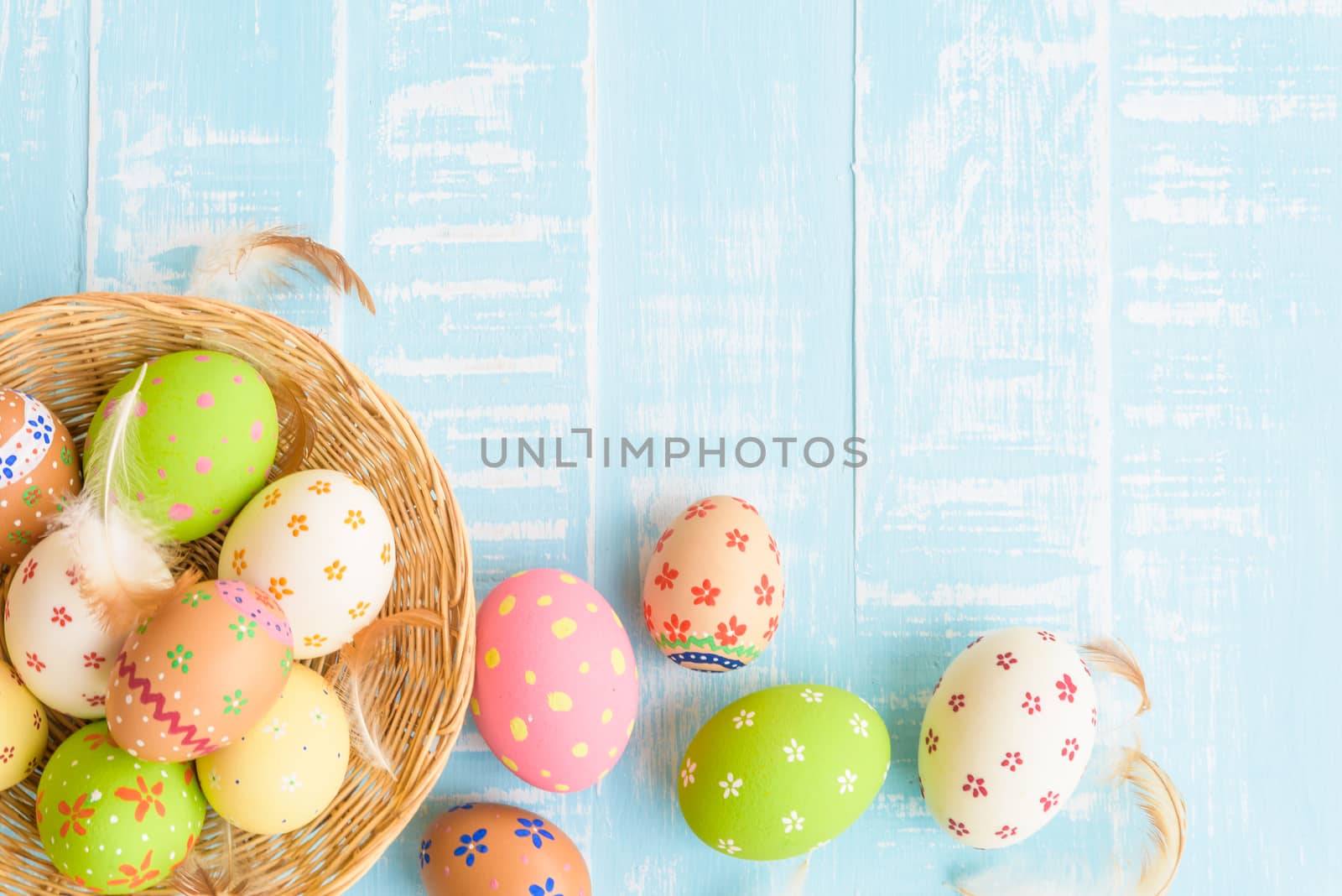 Happy easter! Colorful of Easter eggs in nest on pastel color bright green and white wooden background.