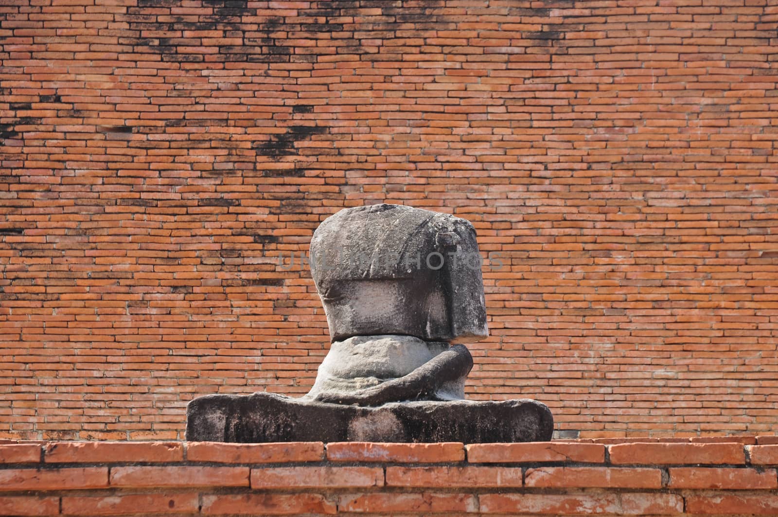 Sitting ancient Buddha statue in Thailand old brick temple