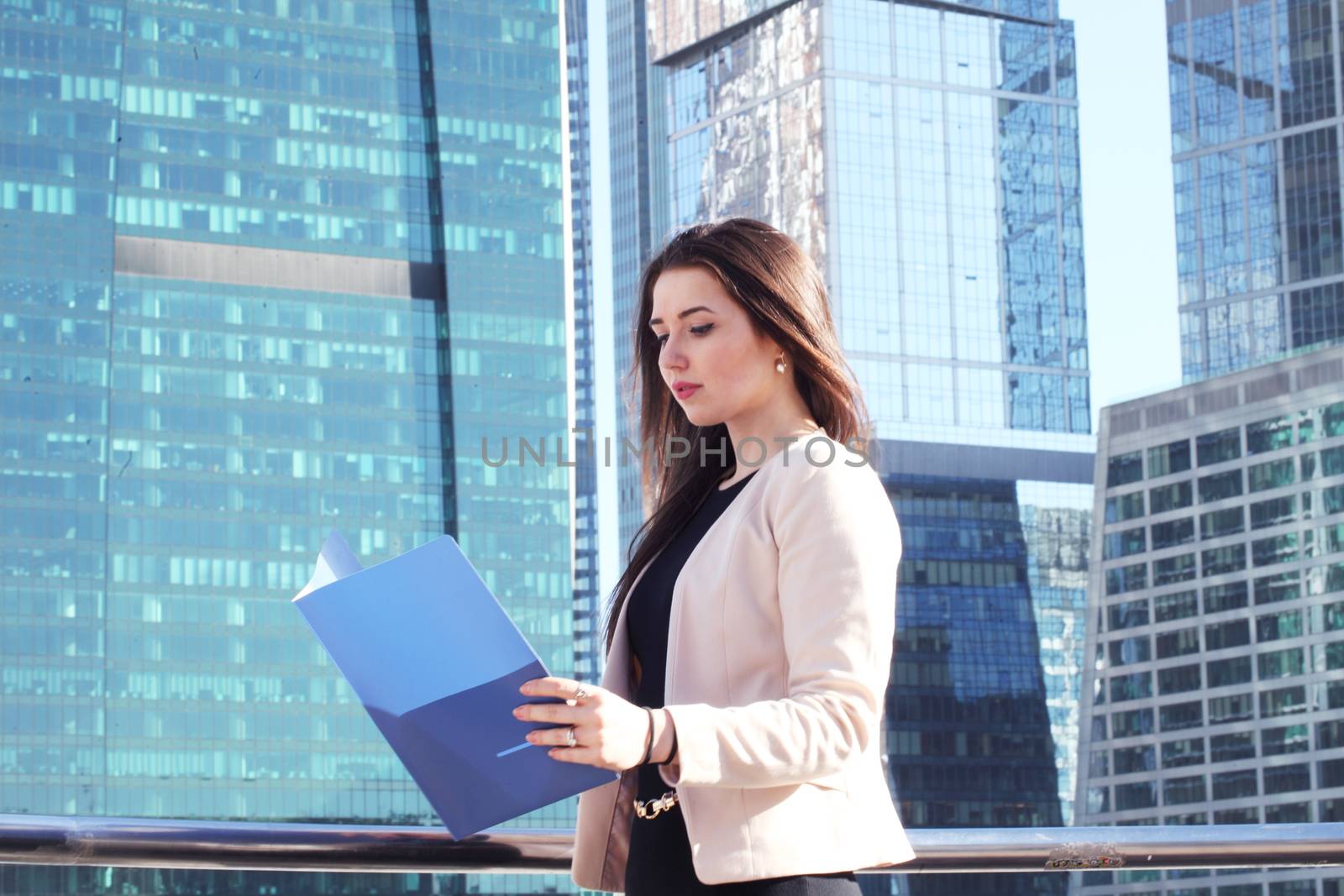 Young beautiful businesswoman outdoors at skyscraper background