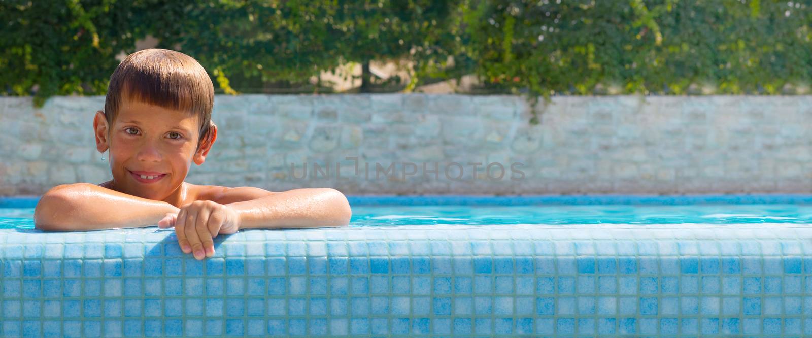 Happy boy at swimming pool by destillat