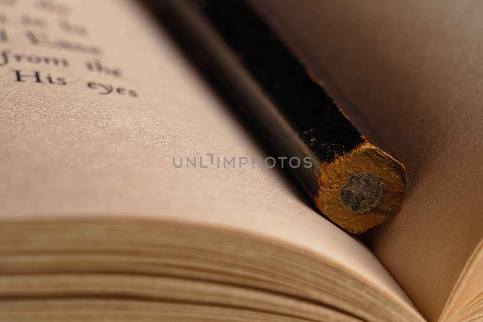 close-up of a black pencil inside of an open book