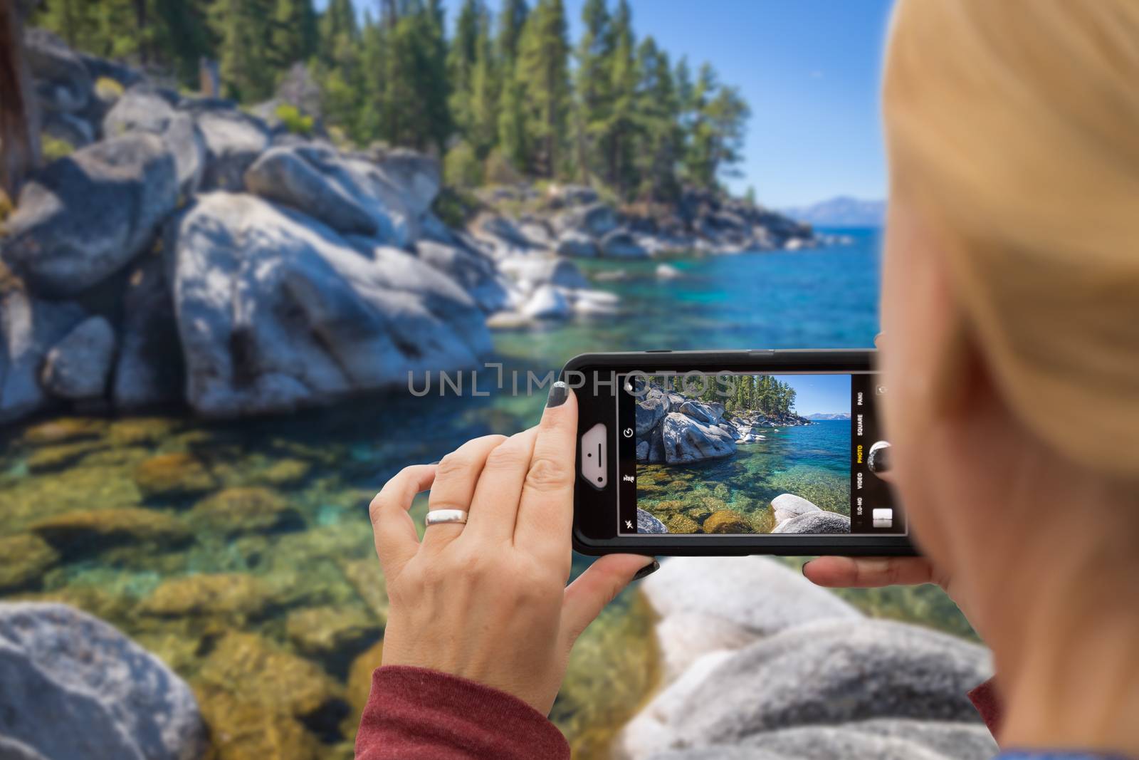 Woman Taking A Beautiful Lake Picture with Her Smart Phone.