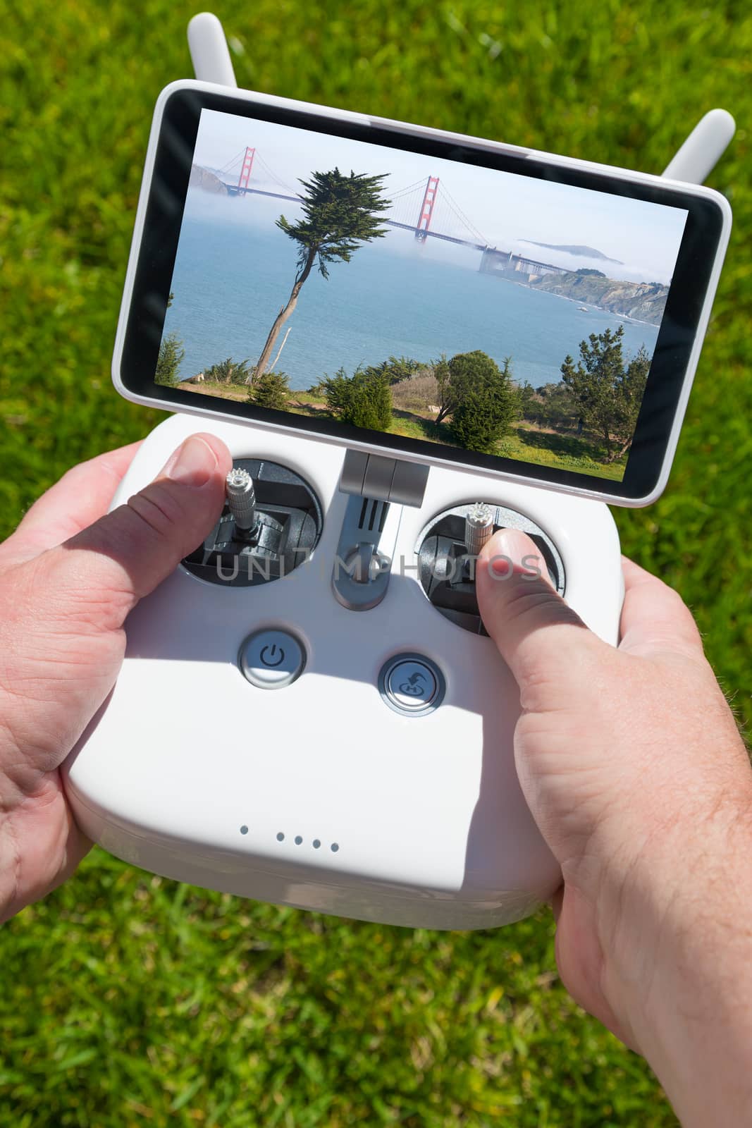 Hands Holding Drone Quadcopter Controller With Golden Gate Bridge View on Screen.