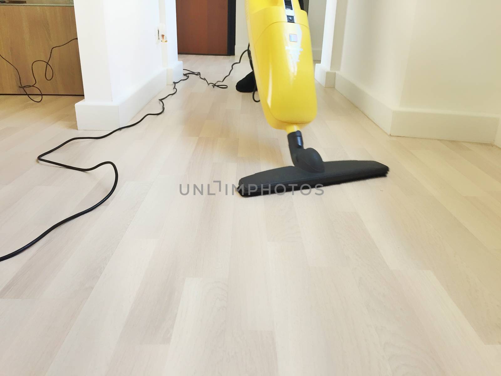 close up view of an electric broom cleaning a wooden floor