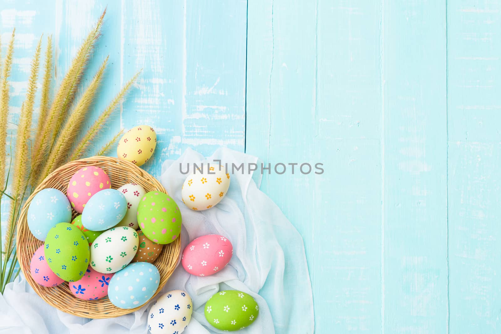 Happy easter! Colorful of Easter eggs in nest with paper star, flower and Feather on pastel color bright blue and white wooden background.