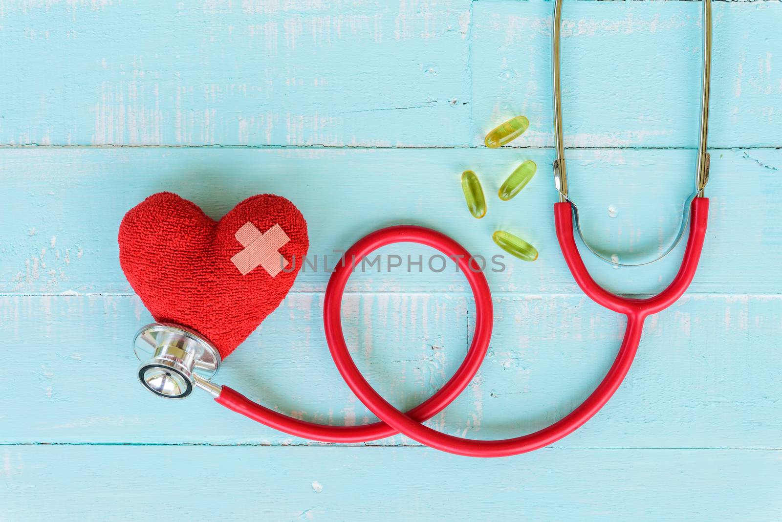 World health day, Healthcare and medical concept. Red heart with Stethoscope, notepad or notebook, thermometer and yellow Pill on Pastel white and blue wooden table background texture.