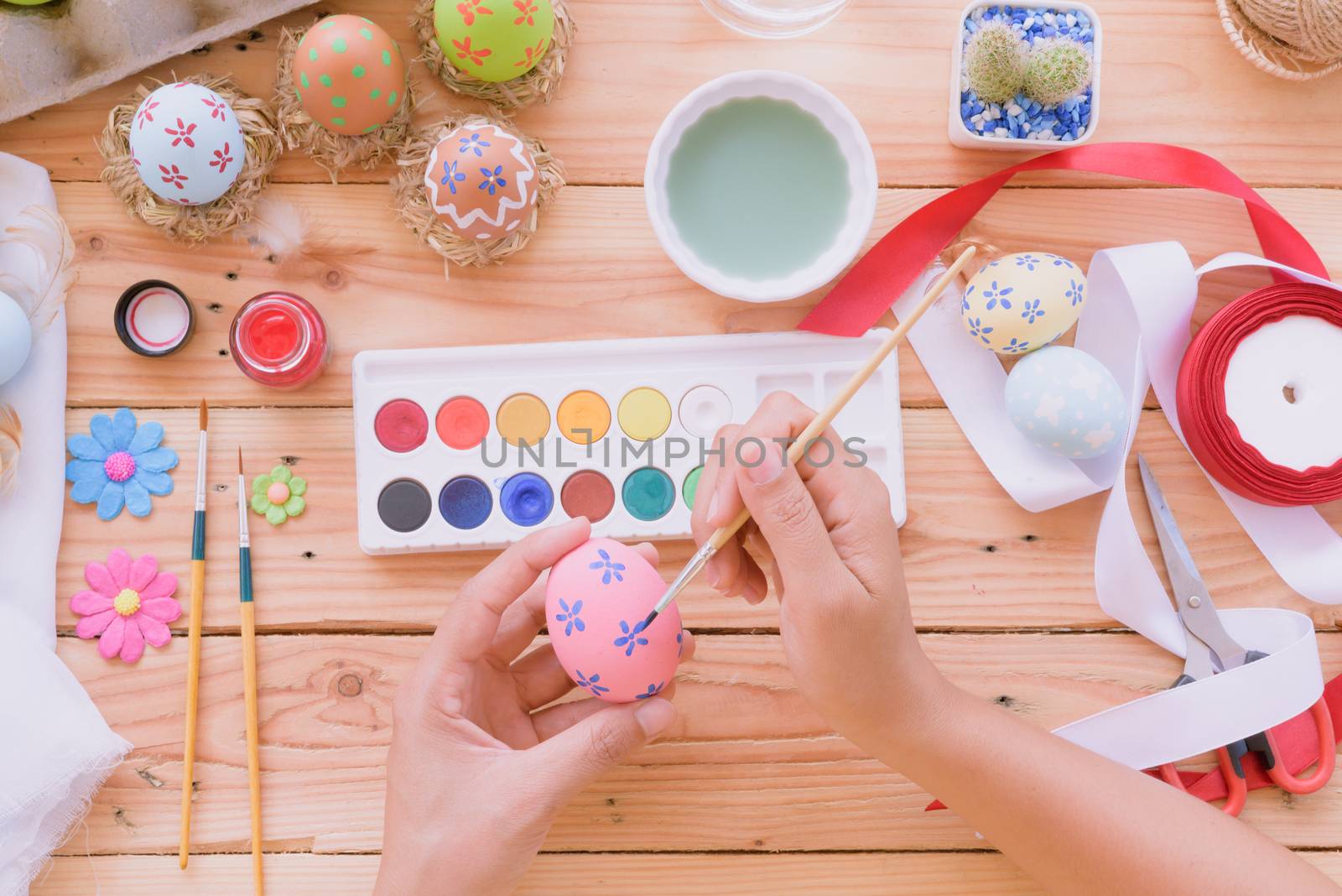 Happy easter! A woman hand painting Easter eggs. Happy family preparing for Easter.