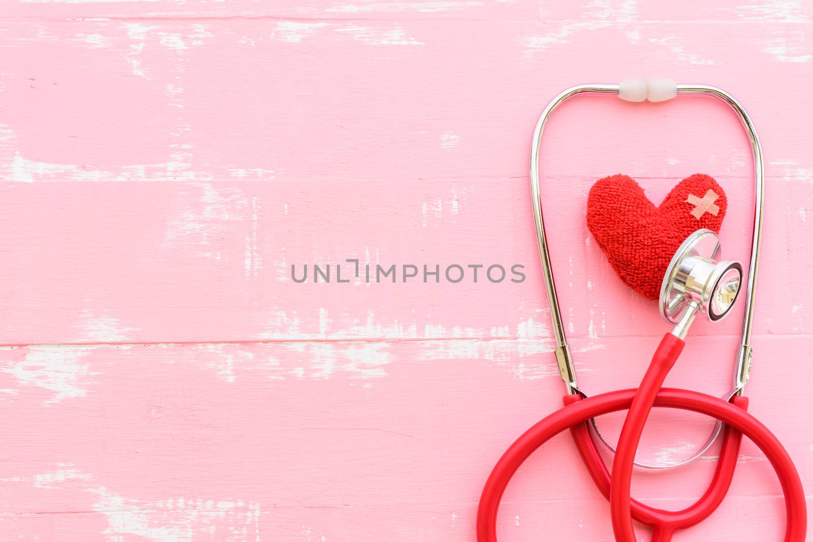 World health day, Healthcare and medical concept. Red heart with Stethoscope, notepad, thermometer and yellow Pill on Pastel white and pink wooden background.