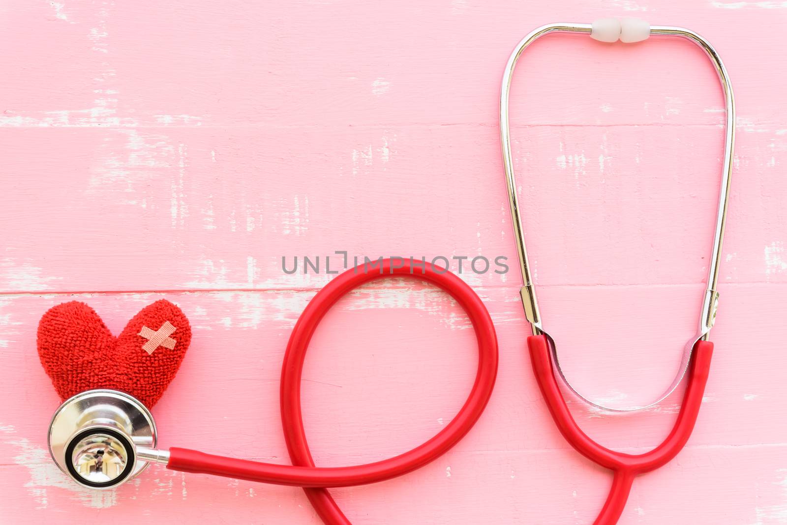 World health day, Healthcare and medical concept. Red heart with Stethoscope, notepad, thermometer and yellow Pill on Pastel white and pink wooden background.