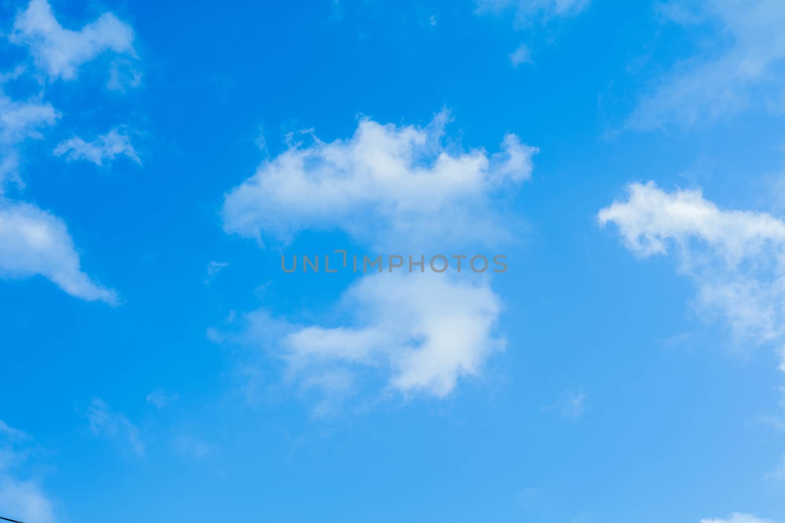 Deep blue bright sky with white fluffy clouds