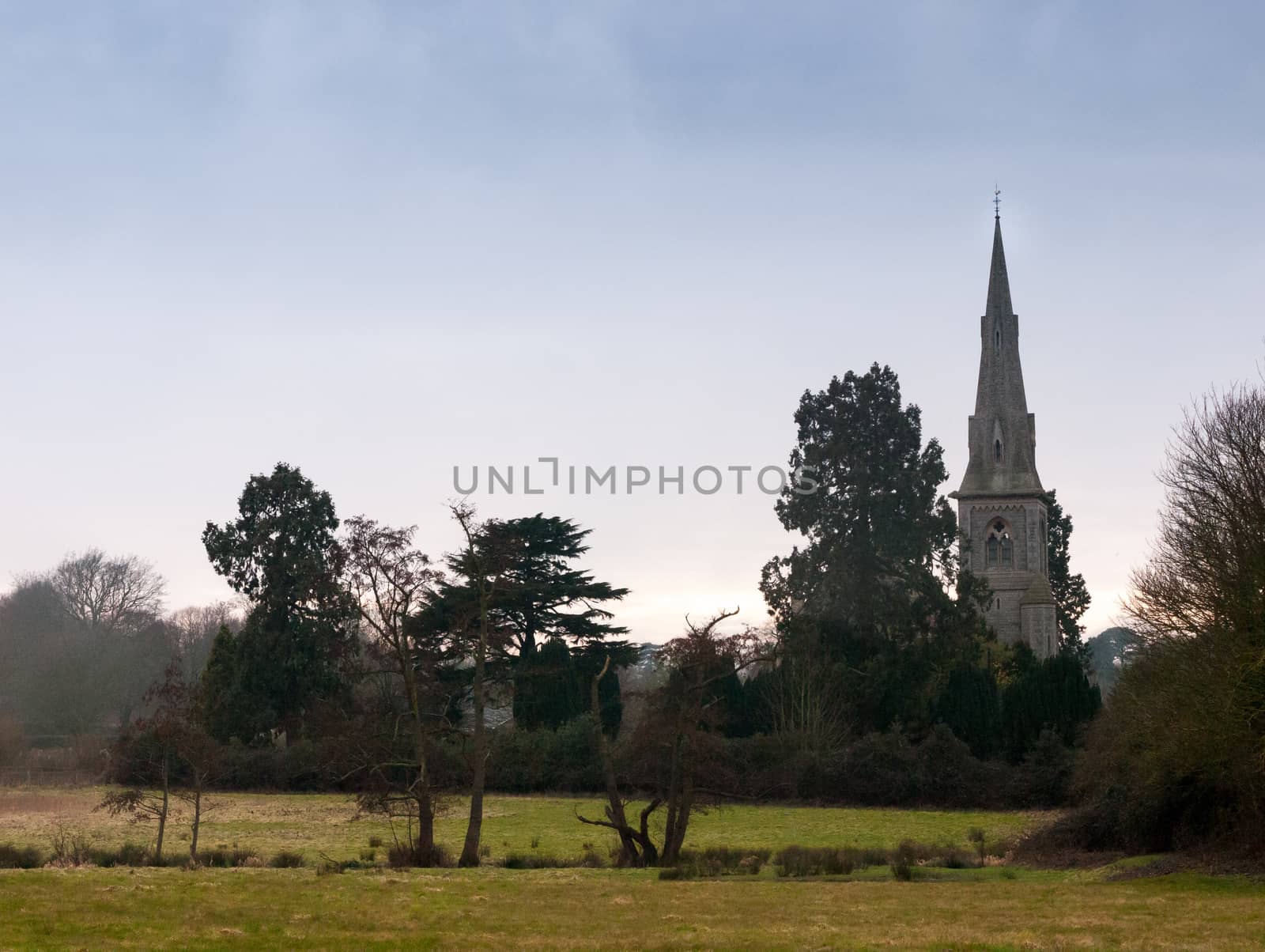 Mistley christian church as seen from over a field with trees in spring; essex; england; uk