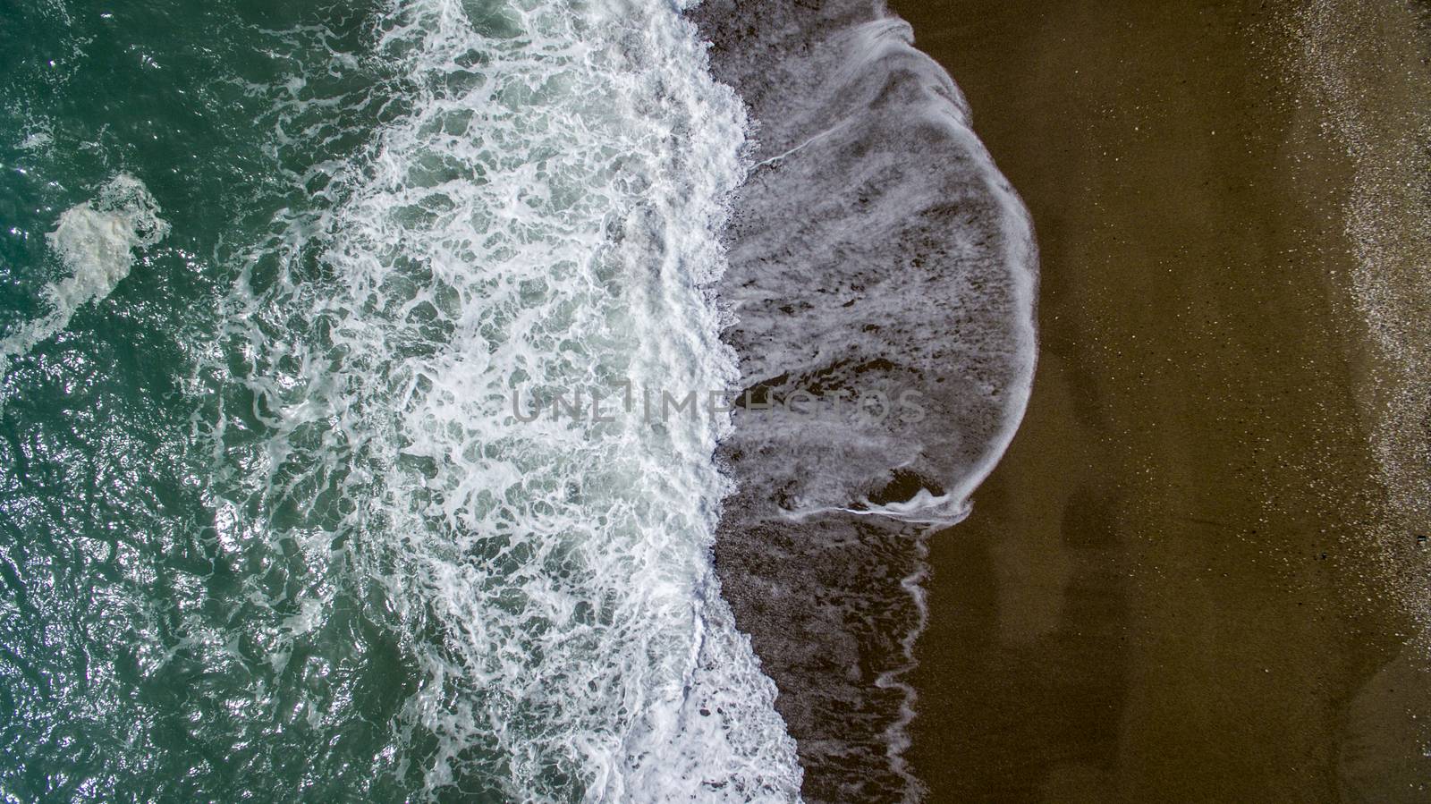 Aerial view waves break on white sand beach. by oaltindag