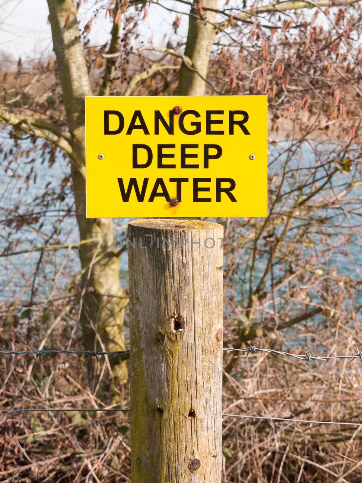 yellow and black sign danger deep water lake; essex; england; uk
