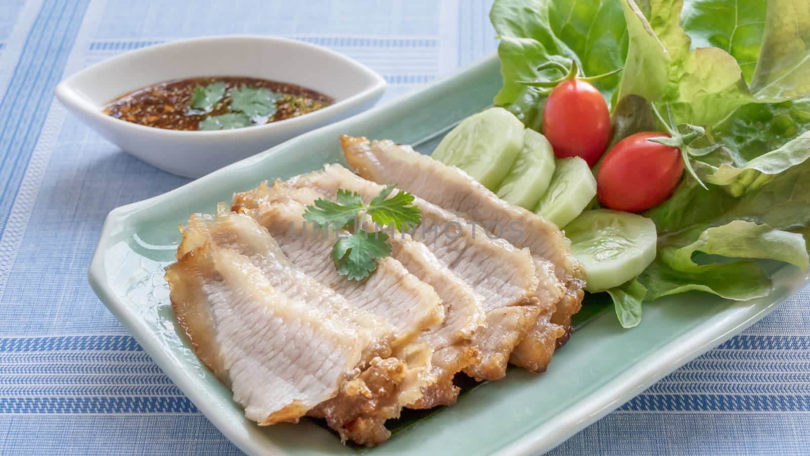 slice of grilled pork served with fresh vegetable and spicy sauce , Thai style food