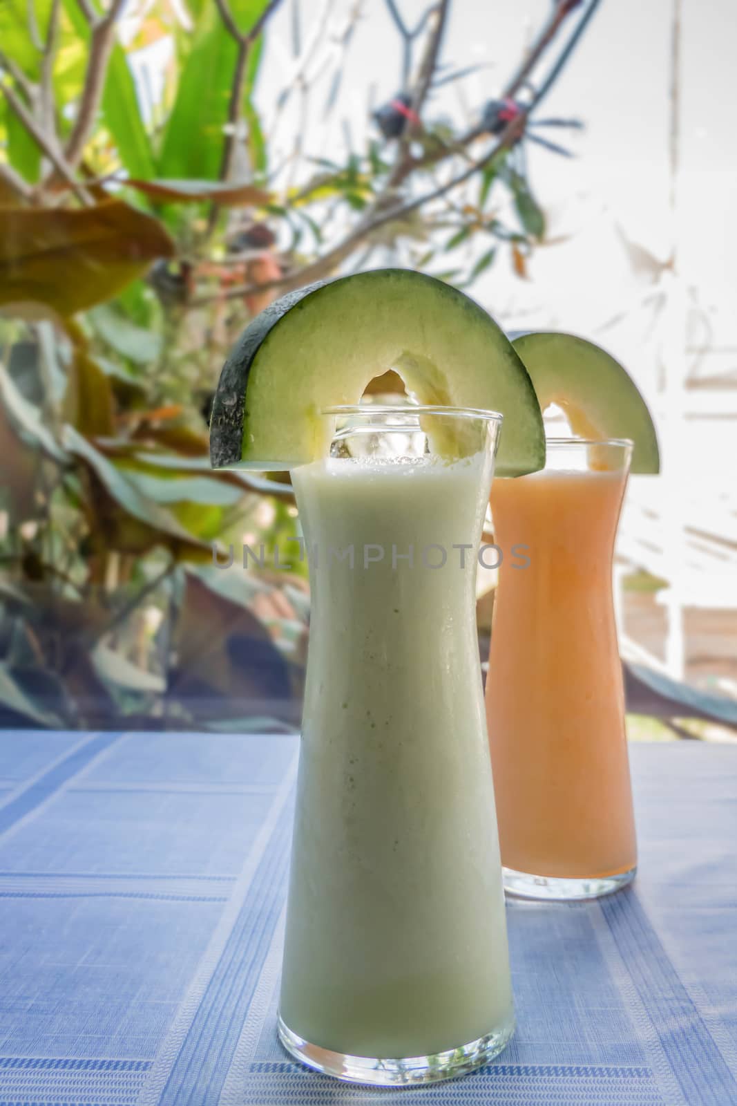 Fresh melon smoothie in a glass on the table