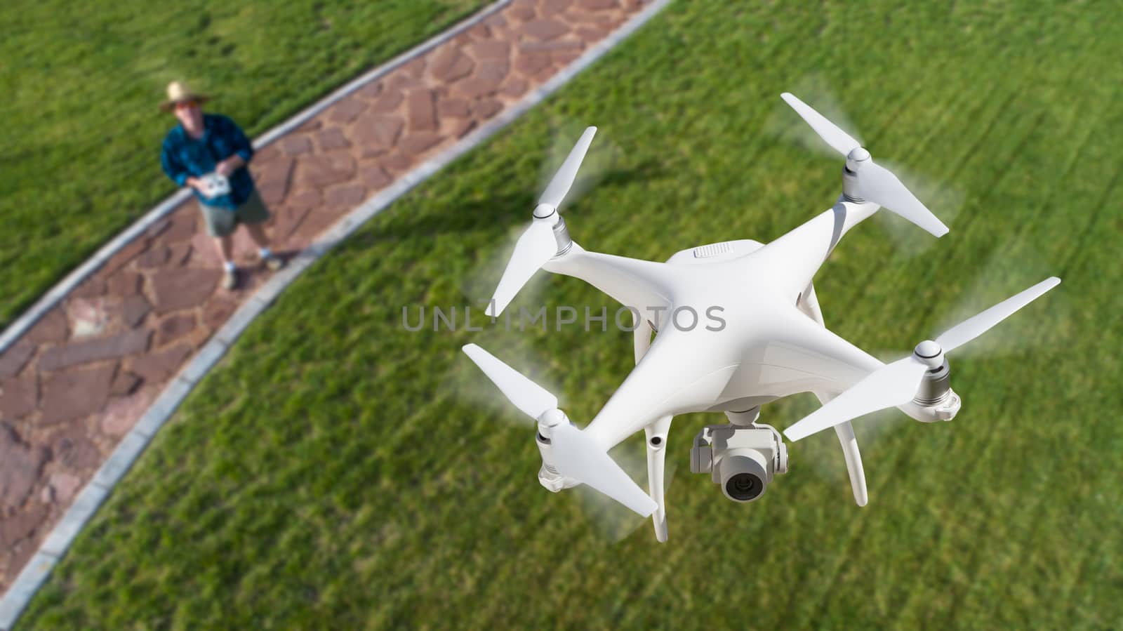 Drone Quadcopter (UAV) In Air Above Pilot With Remote Controller.