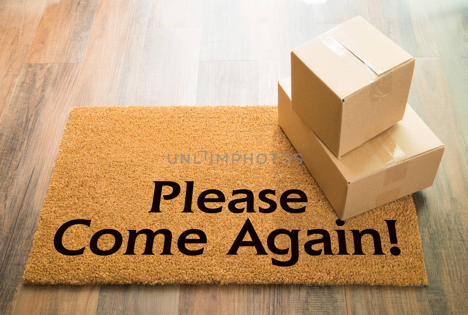 Please Come Again Welcome Mat On Wood Floor With Shipment of Boxes.