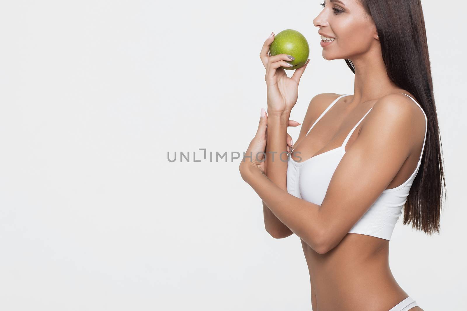 Attractive smiling woman portrait on white background with apple.