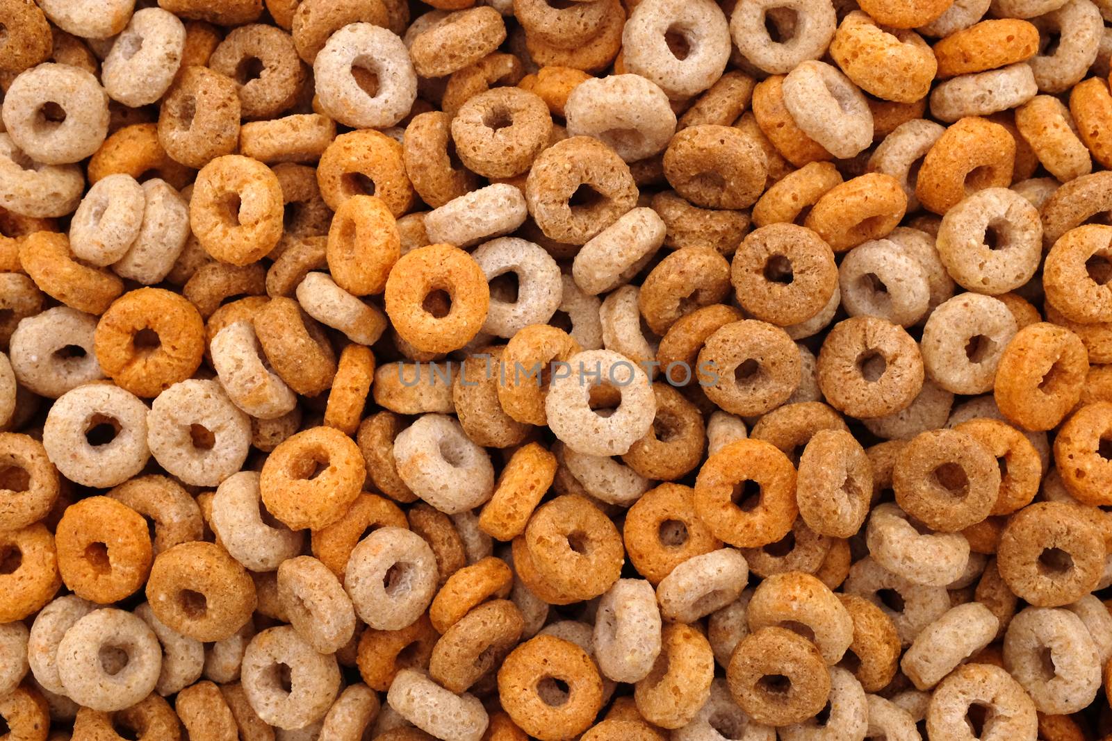 Multigrain hoops breakfast cereal - rings of wheat, barley, rice, oats and maize - as an abstract background texture