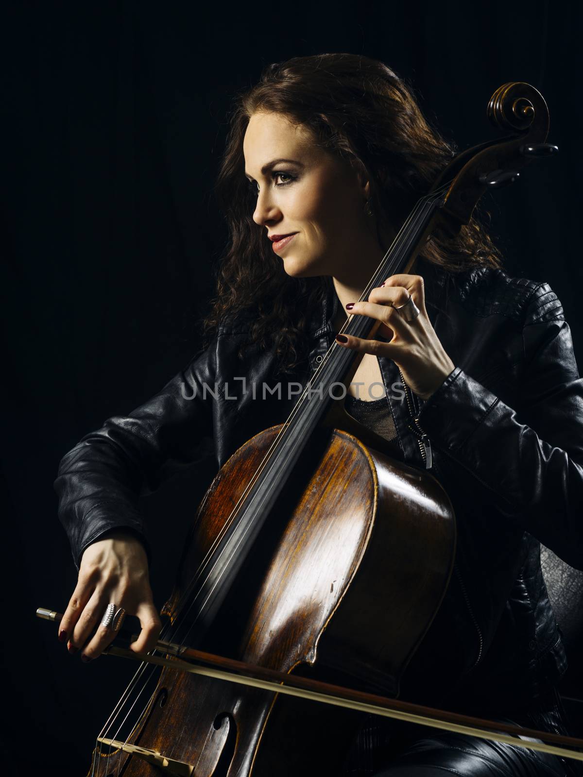 Photo of a beautiful woman playing her old cello.