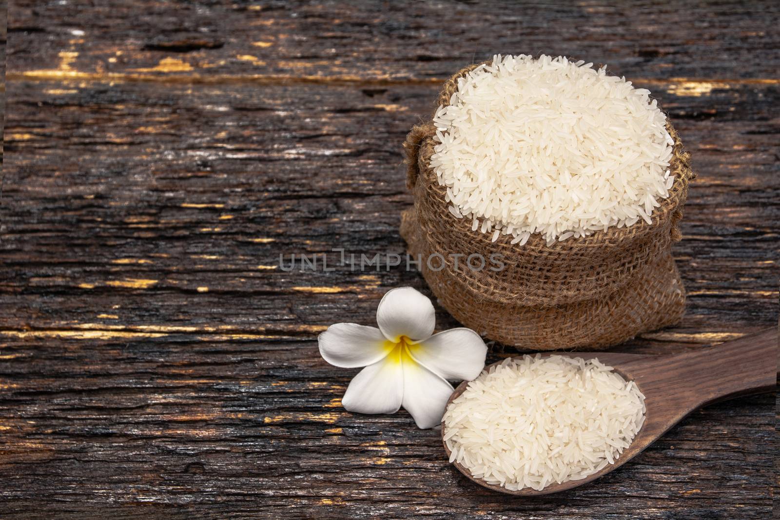 White uncooked rice with White uncooked  rice on wooden spoon, Thai rice on wooden background
