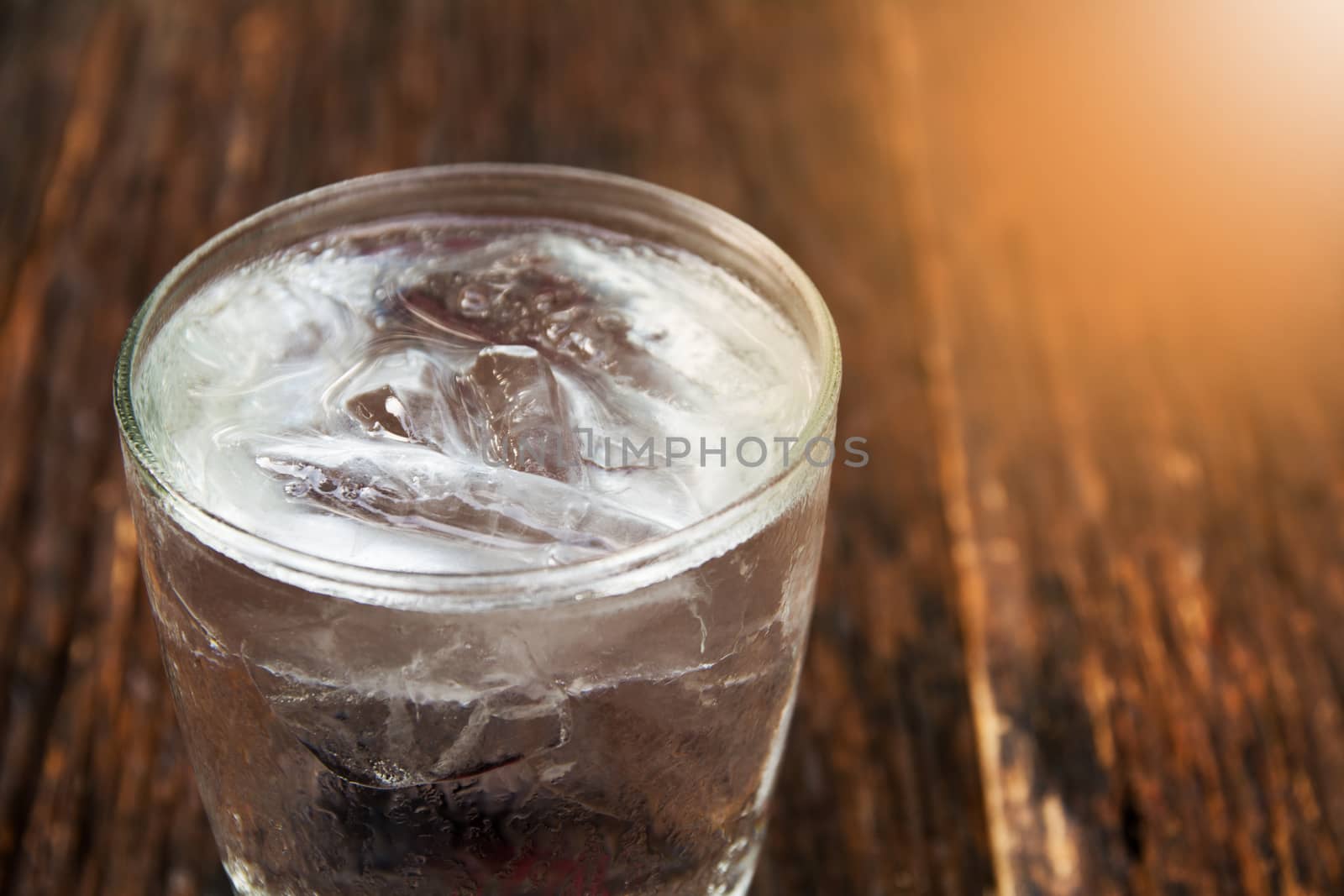 Ice cold water in glass on wooden table for healthy