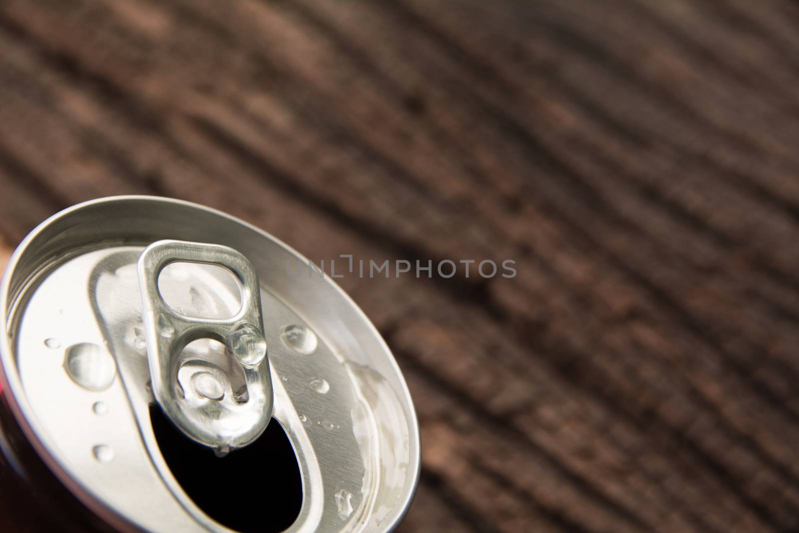 Top of an iron can. Can with a drink of cola on wooden background