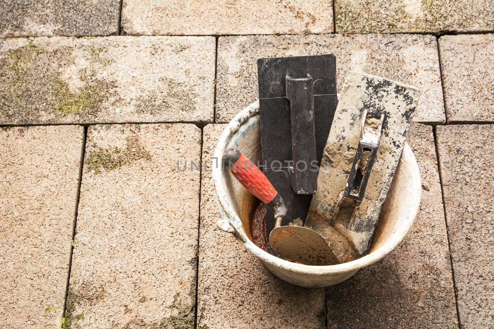 Construction tools or construction equipment with bucket on brick ground